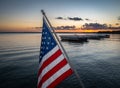 American Flag On Angled Pole With Marina And Water At Sunset