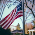 American Flag on the Background of Houses and Trees, on the Street. Close for Memorial Day or 4th of July. Royalty Free Stock Photo