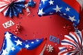 American flag balloons, paper fans, decorations on red background.