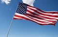 american flag blowing in the wind with blue sky Royalty Free Stock Photo