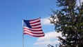 American Flag blowing in the wind with a blue sky background. USA American Flag. Waving United states of America famous Royalty Free Stock Photo