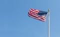 American flag on the blue sky background, turned to the left Royalty Free Stock Photo