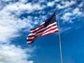 American Flag Flying against bright blue sky horizontal Royalty Free Stock Photo