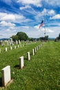 American flag at half-mast against the blue sky over the American military cemetery for those who died in Vietnam