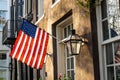 An American Flag hanging outside of a colonial era home Royalty Free Stock Photo