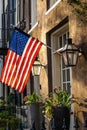 An American Flag hanging outside of a colonial era home Royalty Free Stock Photo