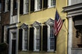 An American flag hanging outside of a colonial era home Royalty Free Stock Photo