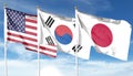 American flag with Japan flag and South Korea flag on cloudy sky. waving in the sky Royalty Free Stock Photo