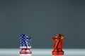 American flag knight chess and China flag knight chess confront each other on transparent board. Chess knight head to head. Confro Royalty Free Stock Photo