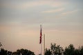 American flag next to one side of football goal post seen at sunset at the end of summer Royalty Free Stock Photo