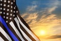 American flag with police support symbol Thin blue line on sunset sky.