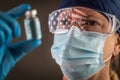 American Flag Reflecting on Female Medical Worker Holding Vaccine Vial Wearing Protective Face Mask and Goggles Royalty Free Stock Photo