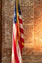 American Flag on Stand, against old brick wall Royalty Free Stock Photo