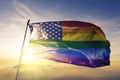 American flag stars gay pride rainbow flag textile cloth fabric waving on the top sunrise mist fog