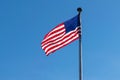 American flag, Stars & Stripes, waving in the wind, against a beautiful blue sky on a sunny summer day Royalty Free Stock Photo