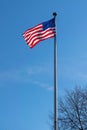 American flag, Stars & Stripes, waving in the wind, against a beautiful blue sky on a sunny summer day Royalty Free Stock Photo
