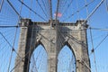 American flag on top of famous Brooklyn Bridge