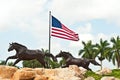 American flag and two running horse statues