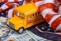 American flag and US banknotes dollar cash money and school bus