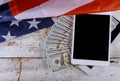 American flag and US dollar banknotes with digital tablet financial office