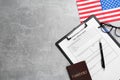 American flag, visa application form, passport and glasses on light grey table, flat lay. Space for text Royalty Free Stock Photo