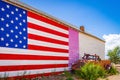 American flag, wall of a house, old fashioned truck on Route 66, is attracting visitors from all of the world Arizona