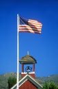American flag waving above one room schoolhouse,