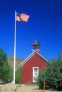 American flag waving above one room schoolhouse,