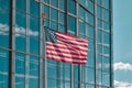 American Flag Waving in Front of Modern Glass Skyscraper Building with Royalty Free Stock Photo