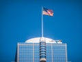 American flag waving on top of a modern skyscraper Royalty Free Stock Photo