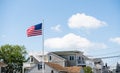 American flag waving in the wind in front of beach houses celebrating the 4th of July, Long Beach Island, NJ, LBI background Royalty Free Stock Photo