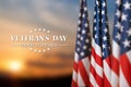 American flags with Text Veterans Day Honoring All Who Served on sunset background.