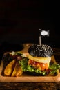 American food background of pork black hamburger with BBQ barbeque sauce on wooden plate in dark tone, slective focused Royalty Free Stock Photo