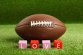 American football ball and cubes with word Love on green grass Royalty Free Stock Photo