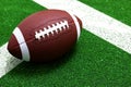 American football ball on field with white line Royalty Free Stock Photo