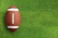 American football ball on grass field background. Royalty Free Stock Photo