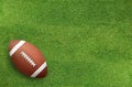 American football ball on grass field background. Royalty Free Stock Photo