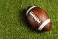 American football ball on green grass field background. Royalty Free Stock Photo