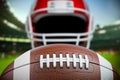 American football ball and helmet on the football arena or stadium Royalty Free Stock Photo