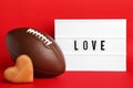 American football ball, lightbox with word Love and heart on red background Royalty Free Stock Photo