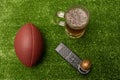 American football ball little football helmet beer and remote control