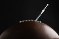 American football ball with syringe on black background, closeup. Doping concept Royalty Free Stock Photo