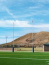 American football goal posts with hill and blue sky. Royalty Free Stock Photo