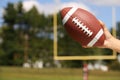 American Football in Hand over Field Royalty Free Stock Photo