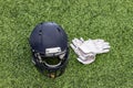 American Football helmet and a pair of white gloves laying on the grass Royalty Free Stock Photo