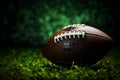 American football on lush green field, set against dark background Royalty Free Stock Photo