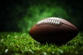 American football on lush green field, set against dark background Royalty Free Stock Photo