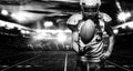 American football player, athlete in helmet with ball on stadium. Black and white photo. Sport wallpaper with copyspace. Royalty Free Stock Photo