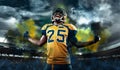 American football player, athlete in helmet with ball on stadium. Sport wallpaper with copyspace. Royalty Free Stock Photo