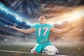 American football player celebrating after scoring a touchdown on the field of big modern stadium with lights and flares at night Royalty Free Stock Photo